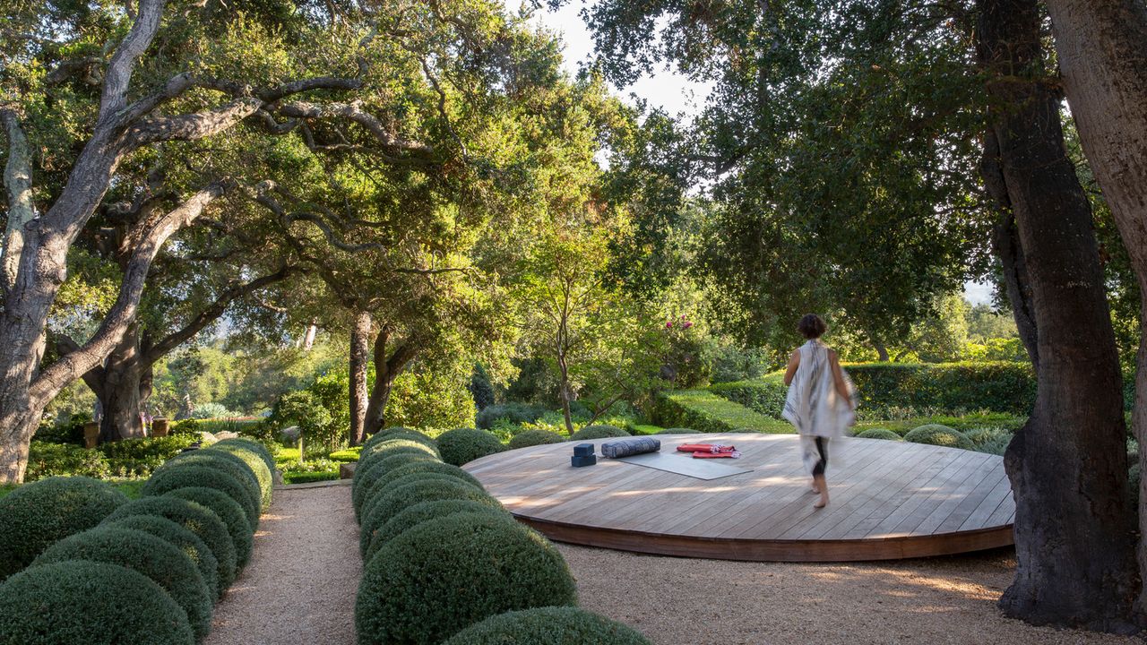 Softly landscaped outdoor residence with layered planting and shaded seating